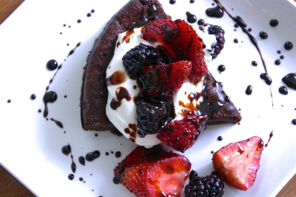 Paleo Flourless chocolate cake with berries, whipped cream and balsamic drizzle